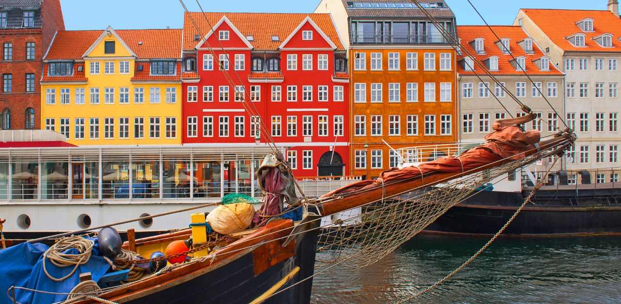 alt="Copenhagen Denmark colorful houses ship vacation destination"