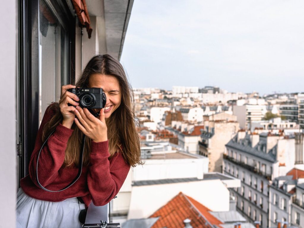 alt="Young women taking a photo at a camera"